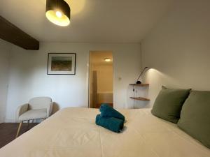 Un dormitorio con una cama con una almohada verde. en La Boulangerie - Campagne - 6 pers - Rêve au Mans, en Thorée-les-Pins