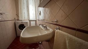 a bathroom with a sink and a washing machine at Casa Astra a Coriano-Riccione in Ospedaletto