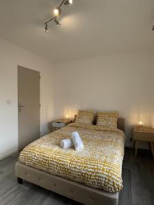 um quarto com uma cama com duas toalhas em La Feuillette - Cosy - Wifi - 4 personnes - Rêve au Mans em Pontlieue