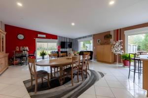 a kitchen and dining room with a wooden table and chairs at Le Bois D'Ourné - Nature - Piscine - 7p - Rêve au Mans in Guécélard