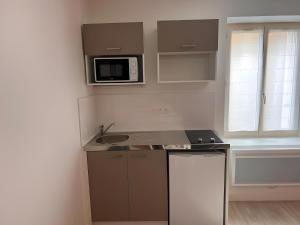 a small kitchen with a sink and a microwave at Les 24h du Mans - Campagne - 4pers - Rêve au Mans in Saint-Mars-sous-Ballon