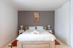 a bedroom with a large white bed with white sheets at Le Bois D'Ourné - Nature - Piscine - 7p - Rêve au Mans in Guécélard