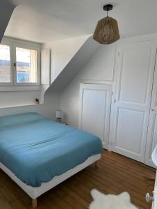 ein Schlafzimmer mit einem Bett mit blauer Bettwäsche und einer Treppe in der Unterkunft Le Contemporain - 5p - Centre Ecommoy - Rêve au Mans in Écommoy