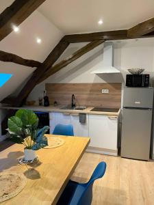 eine Küche mit einem Holztisch und blauen Stühlen in der Unterkunft Le Contemporain - 5p - Centre Ecommoy - Rêve au Mans in Écommoy