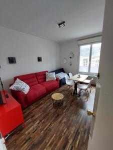 a living room with a red couch and a table at La Bonne Adresse - Gare - Hyper centre - 4 personnes - Rêve au Mans in Le Mans