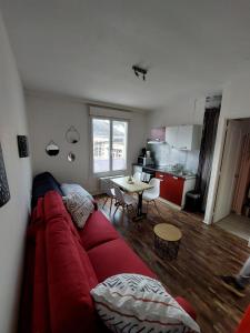 een woonkamer met een rode bank en een tafel bij La Bonne Adresse - Gare - Hyper centre - 4 personnes - Rêve au Mans in Le Mans