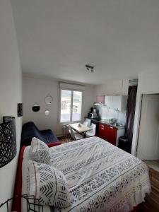 een kleine slaapkamer met een bed en een keuken bij La Bonne Adresse - Gare - Hyper centre - 4 personnes - Rêve au Mans in Le Mans