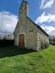 an old building with a door in the grass at La Grange - Campagne - Piscine 15p - Rêve au Mans in Thorée-les-Pins