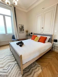 a bedroom with a large bed with orange and yellow pillows at Le Nomade - Gare - 3 pers - Rêve au Mans in Le Mans