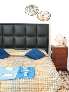 a bed with a black headboard and two plates on the wall at LA CASA DEI PARGOLI JUNIOR in Matera