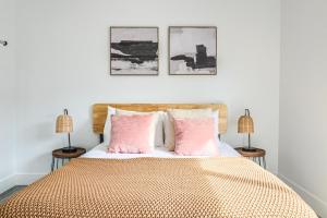 una camera da letto con un letto con cuscini rosa e 2 lampade di Great & Comfy 2BDR Redondo Beach a Redondo Beach