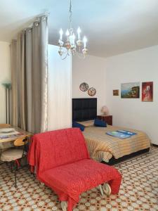 a bedroom with a bed and a red chair at LA CASA DEI PARGOLI JUNIOR in Matera