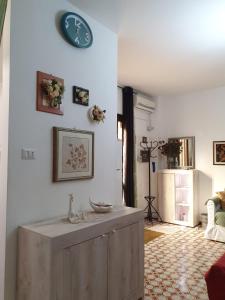 a living room with a clock on the wall at LA CASA DEI PARGOLI JUNIOR in Matera +8 photos