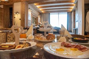 a table topped with plates of breakfast foods at Le Chalet Suite in Livigno