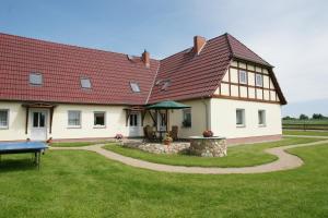 una grande casa bianca con tetto rosso di Ferienhof Willi a Stilow