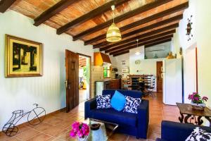 a living room with a blue couch and a table at Can Pep, chalet con piscina en Pollensa in Pollença