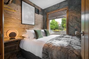 a bedroom with a large bed and a window at Ellerthwaite Place X3 Bed House with Hot Tub in Central Windermere in Windermere