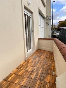 einen Balkon mit Holzboden in einem Haus in der Unterkunft Appartement 4 lits • Tout neuf in Montreuil