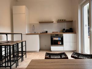 cocina con armarios blancos, mesa y sillas en Appartement 4 lits • Tout neuf, en Montreuil