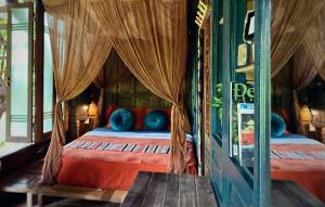 1 dormitorio con 1 cama con sábanas rojas y almohadas azules en Lua Pu Luong en Pu Luong