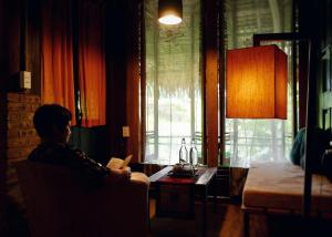 a woman sitting in a chair reading a book at Lua Pu Luong in Pu Luong