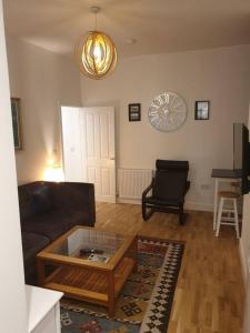 een woonkamer met een bank en een salontafel bij Stylish ground floor 2 bedroomed apartment. in Barrow in Furness