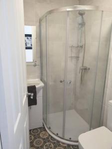 a bathroom with a shower with a toilet and a sink at Stylish ground floor 2 bedroomed apartment. in Barrow in Furness