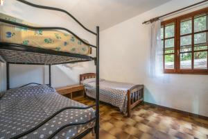 een slaapkamer met 2 stapelbedden en een raam bij La Casa delle Rose in Solanas