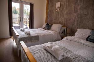 a bedroom with two beds and a window at Cross Lane Cottage in Pudsey