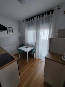 a small kitchen with a white table and a window at M&M Apartment in Velika Gorica