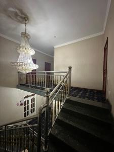 a staircase with a chandelier in a building at Hello Dushanbe Guest House in Dushanbe