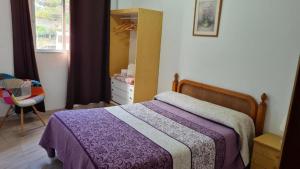 a bedroom with a bed and a dresser and a mirror at Apartamentos El Valle in Frontera