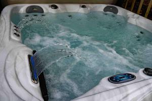 a jacuzzi tub with water pouring into it at Cross Lane Cottage in Pudsey