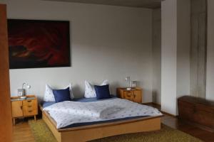 a bedroom with a large bed with blue pillows at Stadtvilla in Murnau am Staffelsee