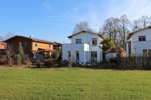 Ein weißes Haus mit einem Zaun auf einem Feld in der Unterkunft Stadtvilla in Murnau am Staffelsee