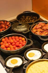 a stove top with various dishes of food on it at EVOLUTION Lisboa Hotel in Lisbon