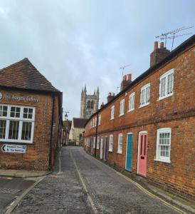 an empty street with brick buildings and a cathedral at Pearls Cottage in Farnham