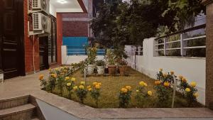 un giardino con fiori gialli di fronte a un edificio di BED LUCKS near Huda Metro sector 40 a Gurgaon