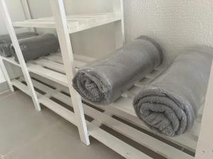 a roll of grey towels on a shelf at POUSADA RIO PERUYPE in Nova Viçosa