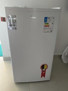 a white refrigerator with stickers on the side of it at POUSADA RIO PERUYPE in Nova Viçosa