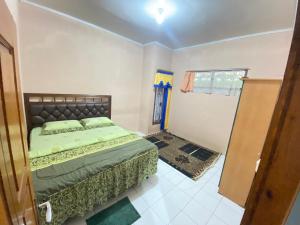 ein Schlafzimmer mit einem Bett in der Ecke eines Zimmers in der Unterkunft Villa Sunda Ciwidey in Nempel