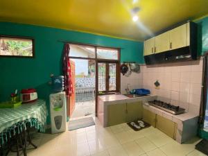 eine Küche mit grünen Wänden, einem Tisch und einem Fenster in der Unterkunft Villa Sunda Ciwidey in Nempel
