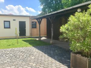 a house with a brick walkway in a yard at die Senfbude - wunderschöne Apartments für 4 Personen mit Terrasse & Stellplatz in Leipzig