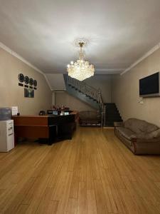 sala de estar con sofá y lámpara de araña en Hello Dushanbe Guest House en Dusambé