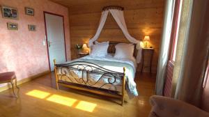 - une chambre avec un lit à baldaquin dans l'établissement L'Ancienne Cure, à Besain