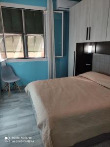 sypialnia z łóżkiem, krzesłem i oknami w obiekcie Il cortiletto w mieście Vado Ligure