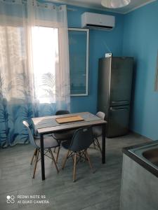 uma cozinha com uma mesa com 2 cadeiras e um frigorífico em Il cortiletto em Vado Ligure