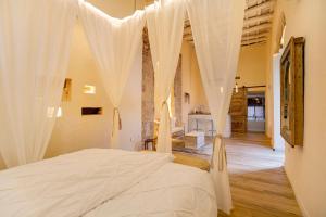 a bedroom with a bed with white curtains at Private Spa in Kangen House Jerez in Jerez de la Frontera