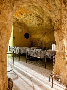 リュイーヌにあるTroglo Papillonの石の洞窟内のベッド1台が備わるベッドルーム1室