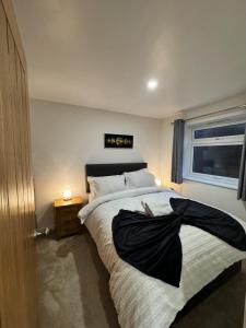 um quarto com uma cama com um cobertor preto em 1A Priscilla Close em Earlham